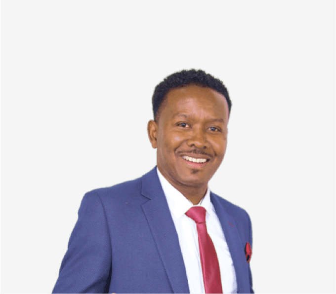 Man in a blue suit with a red tie smiling against a plain background.
