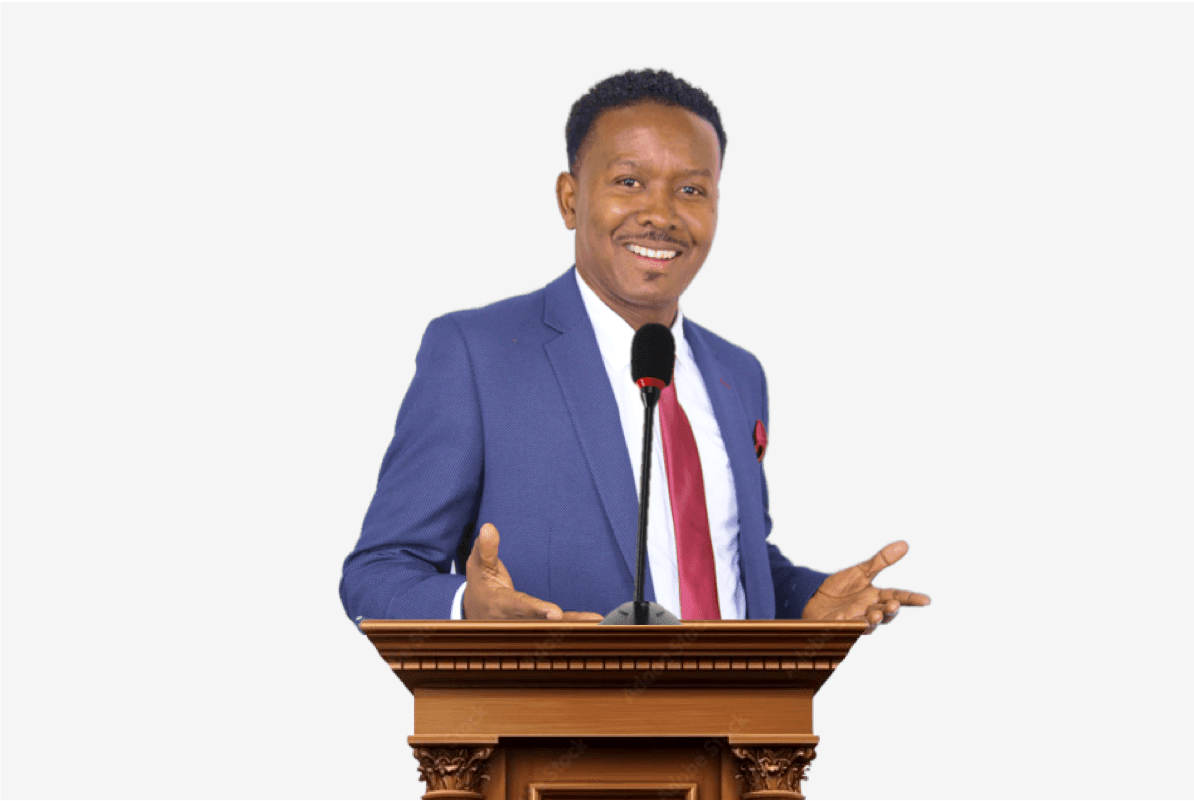 Person in a blue suit and red tie speaking at a wooden podium with a microphone.
