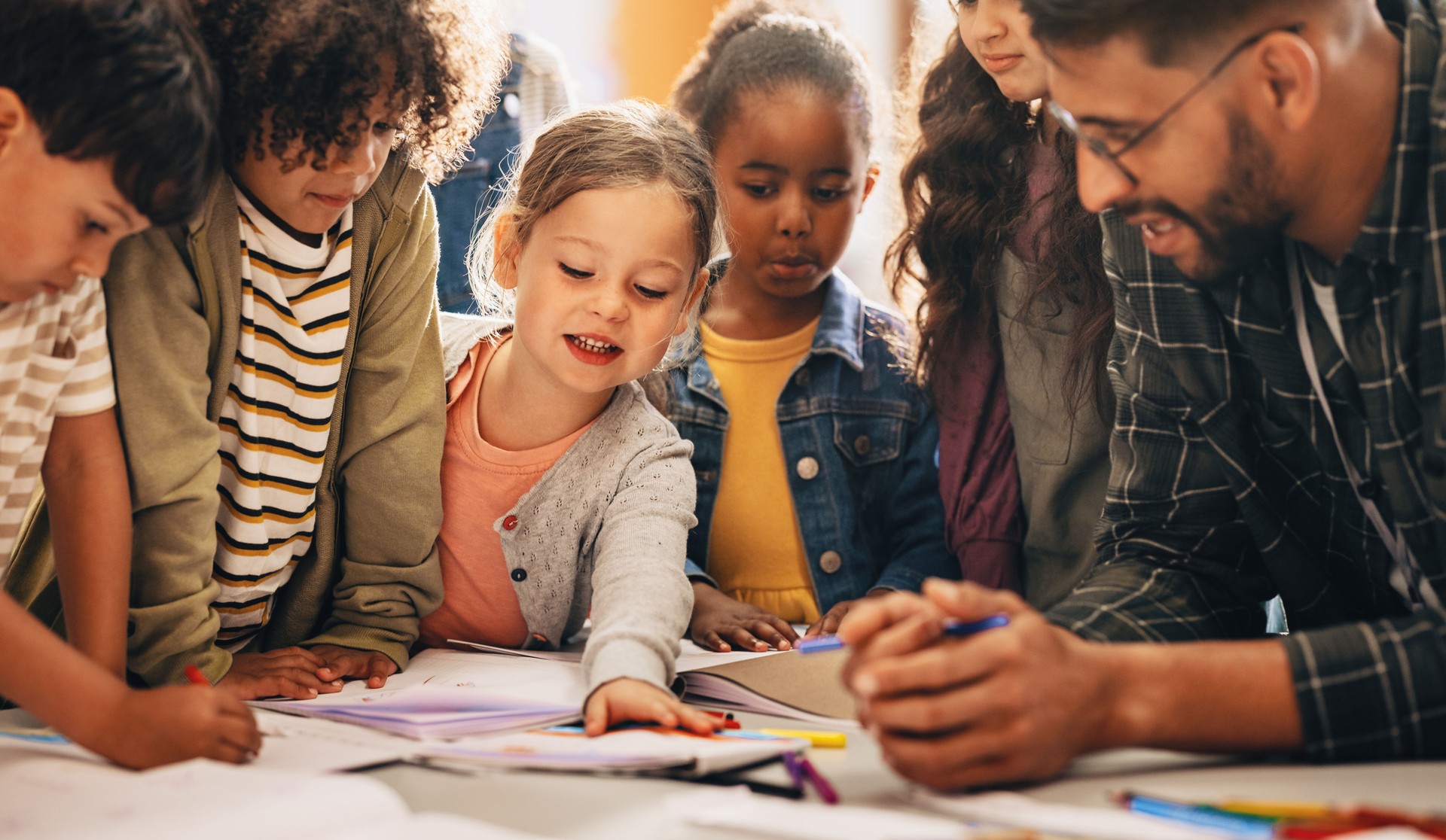 Des élèves réalisant un projet de créativité avec leur enseignant dans une salle de classe